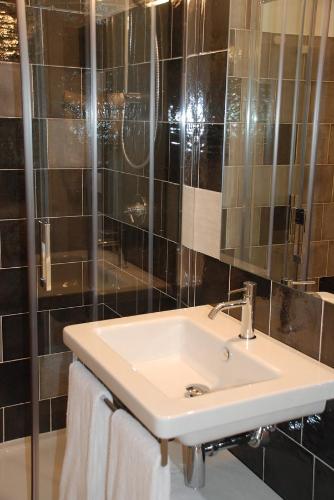 a bathroom with a white sink and a shower at Casa Blanca Matera in Matera