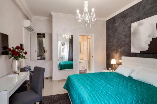 Dreamsrome Suites في روما: غرفة نوم بسرير اخضر ومكتب وثريا