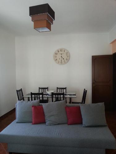 uma sala de estar com um sofá e um relógio na parede em Spacious Central 2 Bedroom Apartment em Setúbal