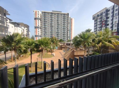 a balcony with palm trees and a tall building at Eqino Swiss Garden Studio with Pool View in Kuantan