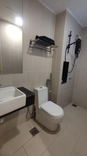 a bathroom with a white toilet and a sink at Eqino Swiss Garden Studio with Pool View in Kuantan
