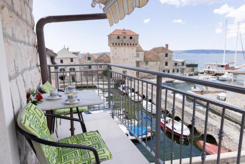 a balcony with a table and a view of a harbor at Apartments Kastilac near the beach in Kaštela