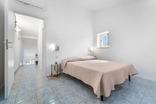a bedroom with a bed in a white room at Domu Istella in SantʼAnna Arresi