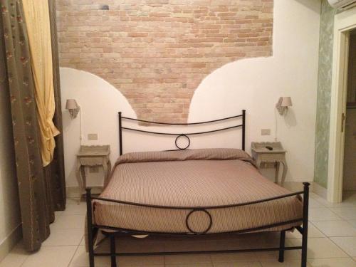 a bed in a room with a brick wall at Le dimore Al Vecchio Teatro in Ortona