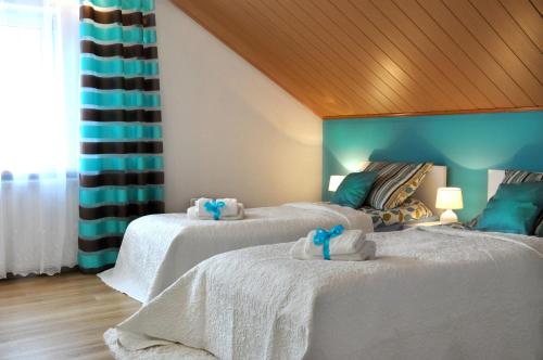 a bedroom with two beds with towels on them at Angel Apartment in Krynica Zdrój