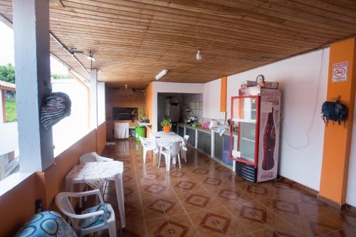 uma cozinha com um frigorífico, uma mesa e cadeiras em Boituhostel em Boituva