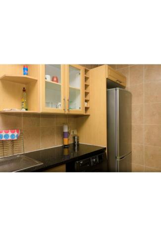 a kitchen with a stainless steel refrigerator and cabinets at Mbuso Guest House in Richards Bay