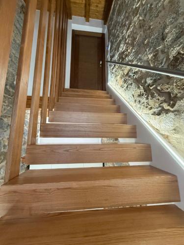 a staircase in a house with wooden floors and a stone wall at Exoria Luxury Rooms & SPA in Nuoro