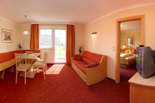 a living room with a couch and a dining room at Apart-Pension Bergland in Ladis