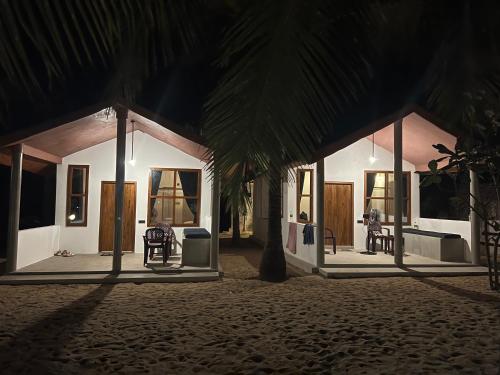 a house with a palm tree in front of it at Sand Dune Beach Resort & Surf Camp in Arugam Bay
