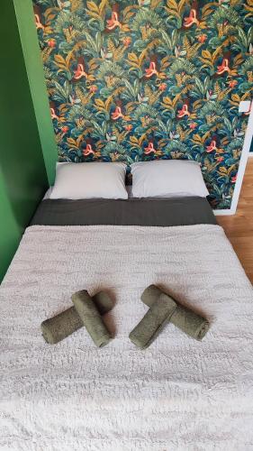 un lit avec deux bûches dessus avec un papier peint dans l'établissement Appartement 90m2, climatisé 3 chambres, à Nice