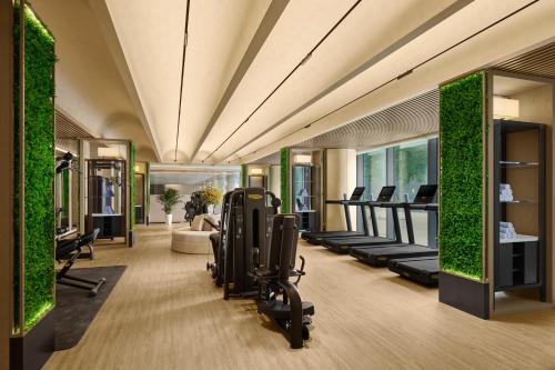 長春市にあるInterContinental Changchun High Tech Zone by IHGの建物内にトレッドミルと植物のあるジム