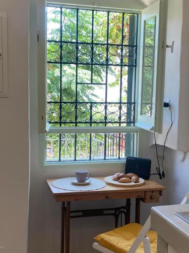 a table with a window and a plate of food at ALEMINAS House 1 in Symi