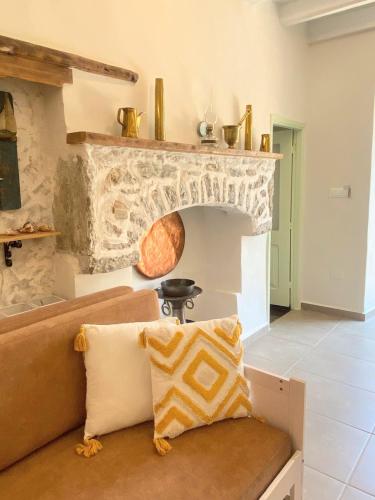 a couch in a living room with a stone fireplace at ALEMINAS House 1 in Symi