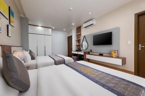 a hotel room with two beds and a flat screen tv at Cat Ba Seoul 2 Hotel & Apartment in Cat Ba