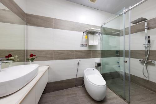 a bathroom with a toilet and a sink and a shower at Cat Ba Seoul 2 Hotel & Apartment in Cat Ba