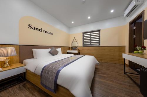 a bedroom with a large bed and a sign on the wall at Cat Ba Seoul 2 Hotel & Apartment in Cat Ba