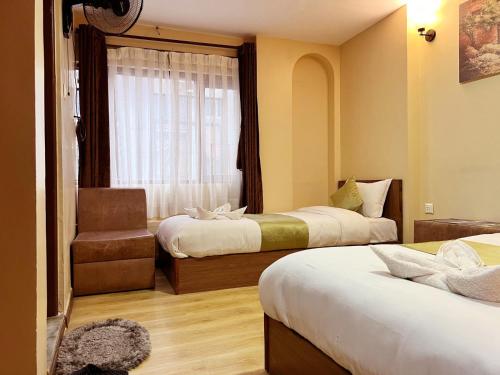 a hotel room with two beds and a window at Holiday Hostel Kathmandu in Kathmandu