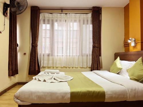 a bedroom with a large bed with a window at Holiday Hostel Kathmandu in Kathmandu