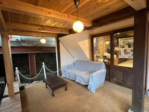 a living room with a couch and a table at 坂東商店guest room藍染めと宿 in Wada