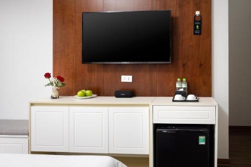 a living room with a tv on a wall at Cat Ba Seoul 2 Hotel & Apartment in Cat Ba