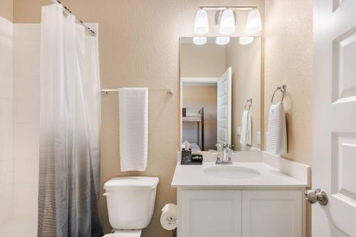 a bathroom with a toilet and a sink and a mirror at Luxury 2St Home, By Austin Airport, Gym, Pool in Austin