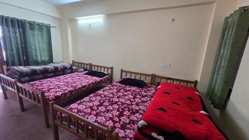 a bedroom with two beds and a couch at Shivpuri House Kedarnath in Kedārnāth