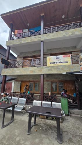 a table and chairs in front of a building at Shivpuri House Kedarnath in Kedārnāth
