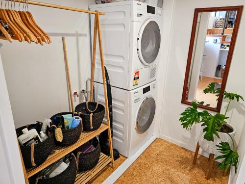 a laundry room with a washer and dryer at Adventurer's Chest - Pohutukawa in Hotwater Beach