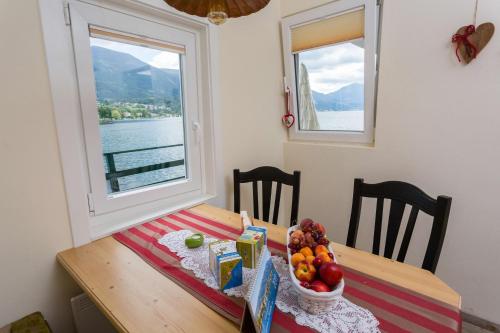 a table with a bowl of fruit and a window at Smileys Seehäuschen in Seeboden