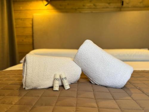 two white towels sitting on top of a bed at Terreforti Luxury Village in Agrigento