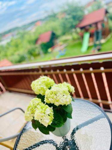 a vase filled with green flowers sitting on a table at Apartman Maša in Brdovec