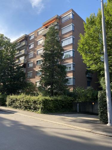 a tallartment building with trees in front of a street at Apartment Arnold in Basel