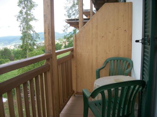 a wooden balcony with a table and chair on it at Agri-park Casa Miramonte in Ronzone