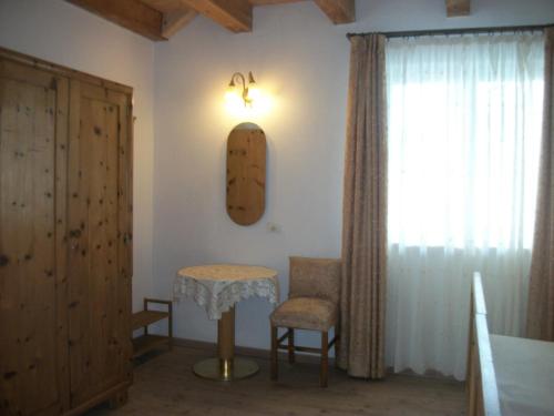 a room with a table and a chair and a window at Agri-park Casa Miramonte in Ronzone