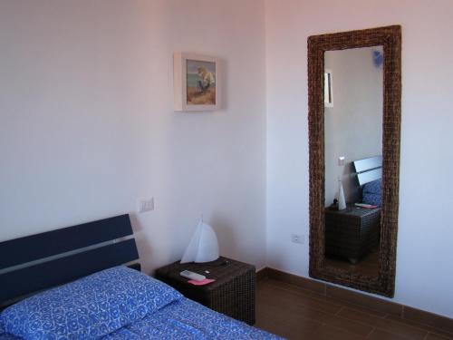 a bedroom with a bed and a mirror at Casa Guerrino in Chiessi