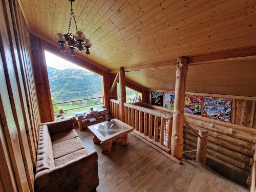 salon z kanapą i dużym oknem w obiekcie Chalet SPA Le Royal Nathalie MN La rouge w mieście La Bresse