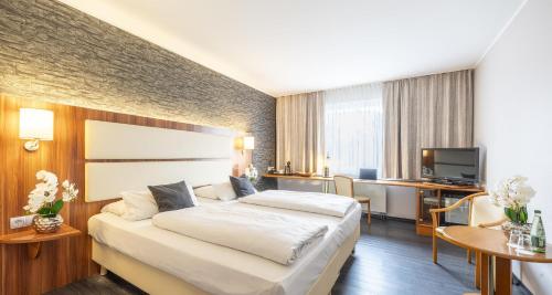 a hotel room with a bed and a television at Best Western Plaza Hotel Zwickau in Zwickau