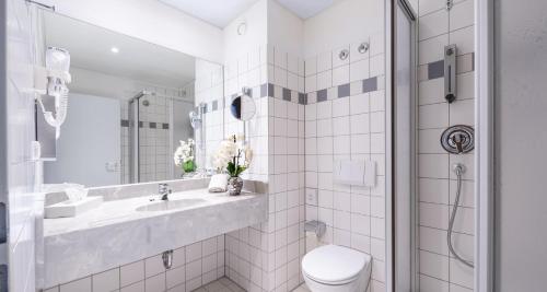 a white bathroom with a sink and a toilet at Best Western Plaza Hotel Zwickau in Zwickau