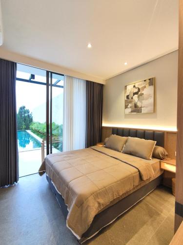 a bedroom with a large bed and a large window at Villa Anvaya in Pasuruan