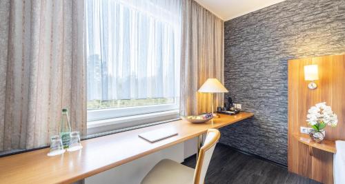 a hotel room with a desk and a window at Best Western Plaza Hotel Zwickau in Zwickau