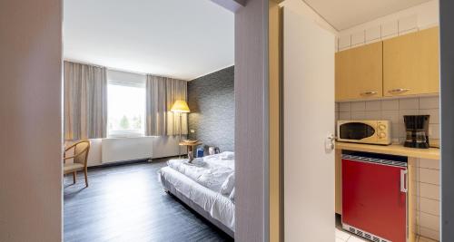 a small room with a bed and a kitchen at Best Western Plaza Hotel Zwickau in Zwickau