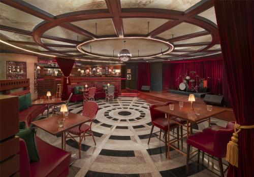 a restaurant with tables and chairs and a ceiling at Grand Hyatt Erawan Bangkok in Bangkok