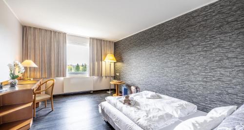 a hotel room with a bed and a table and a desk at Best Western Plaza Hotel Zwickau in Zwickau