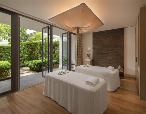 two beds in a room with sliding glass doors at Grand Hyatt Erawan Bangkok in Bangkok