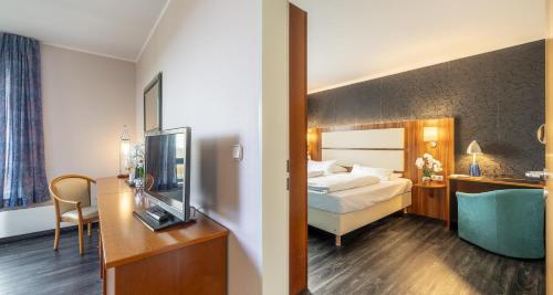 a hotel room with a bed and a television at Best Western Plaza Hotel Zwickau in Zwickau