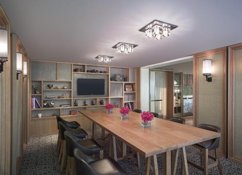 a dining room with a wooden table and chairs at Grand Hyatt Erawan Bangkok in Bangkok