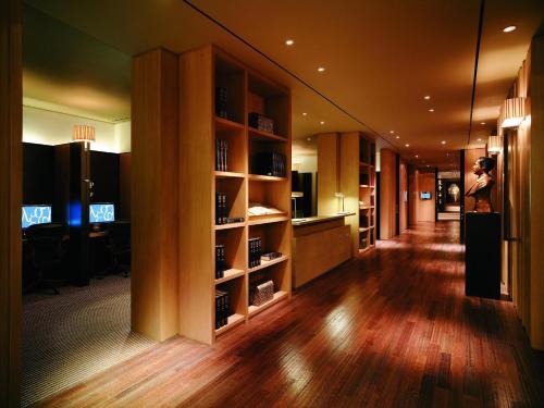 a woman is taking a picture of a hallway with shelves at Grand Hyatt Erawan Bangkok in Bangkok