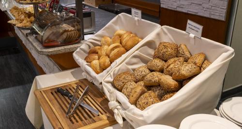 two baskets filled with different types of bread on a table at Best Western Plaza Hotel Zwickau in Zwickau