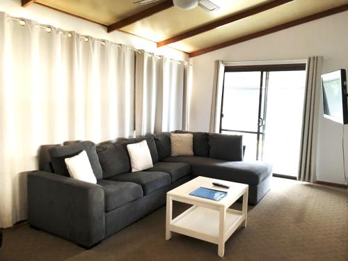 a living room with a couch and a table at Fishing Haven Holiday Park in Palmers Island